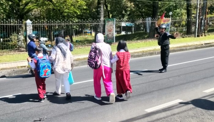 Brimob Jabar  Bantu Anak – anak Sekolah yang Akan Menyeberang di Jalan Besar Lembang – Subang 