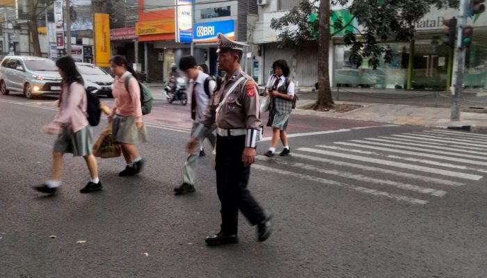 Pelayanan masyarakat dengan Personil Lantas Polsek Cicendo Polrestabes Bandung Membantu Menyebrangkan warga