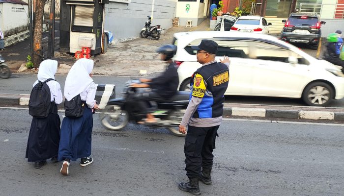 Bhabinkamtibmas Polsek Sukajadi Gatur Lalin dan Bantu Anak Sekolah Menyeberang Jalan