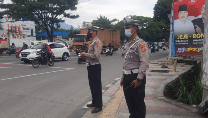 Personil Polsek Cinambo melaksanakan pengaturan lalu lintas guna antisipasi kepadatan kendaraan maupun kerawanan dijalan raya