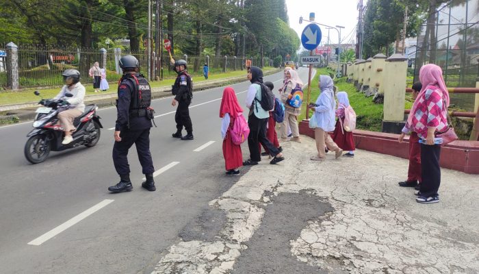 Personel Brimob Batalyon B Pelopor Bantu Anak Sekolah Menyebrang Jalan di Desa Cikole, Lembang