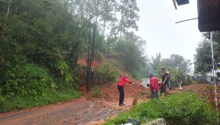 Polsek Banjarwangi Bersama Warga Bersihkan Jalan dari Material Longsor Saat Patroli