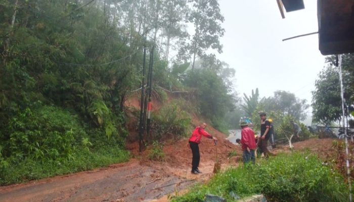 Polisi Bersama Warga Bersihkan Jalan dari Material Longsor Saat Patroli